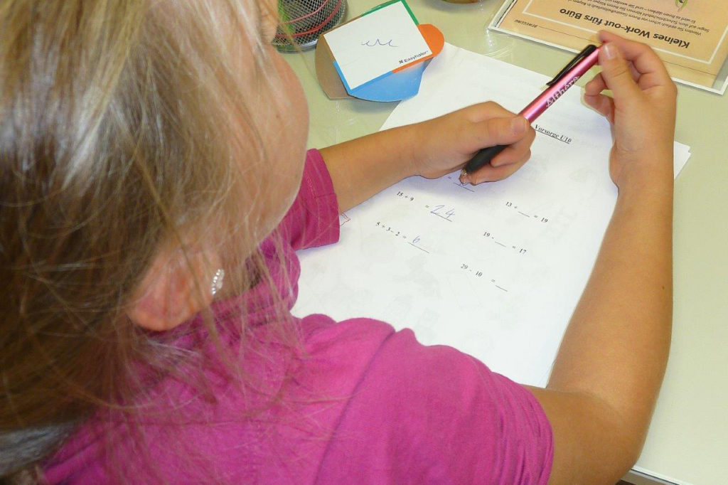 Mädchen bei Mathe-Aufgaben während einer U10-Untersuchung
